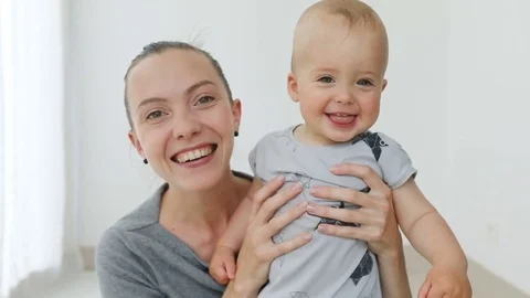 Baby's and mom face while it smiles and laughs Stock Footage