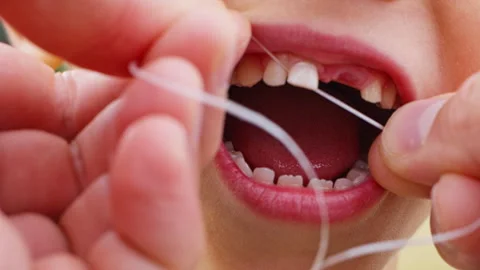 The baby's baby tooth is removed using dental floss. Stock Footage 256215740