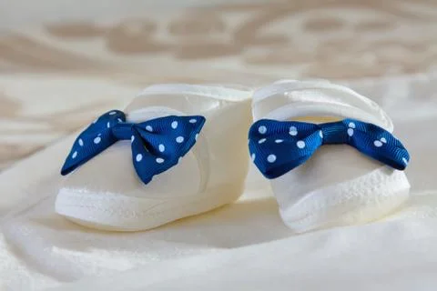 Baby's bootees on a bed Stock Photos