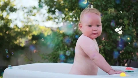 A Baby's Delightful Bubble Bath Adventure in the Summer Sun Stock Footage 278696085