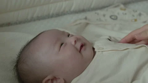 A baby's face with a wide smile while receiving a mother's tummy massage. Stock Footage 194709694