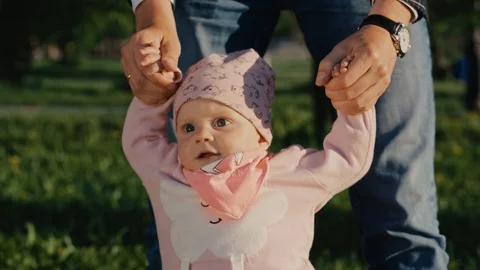 Baby's first steps. Dad helps to take the first steps his daughter Video stock 94440472