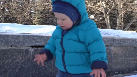 Baby's first steps in the snow Stock Footage 76903861
