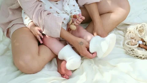 A baby's first steps on a soft blanket, tiny shoes in hand. Captures the Stock Footage 263049898