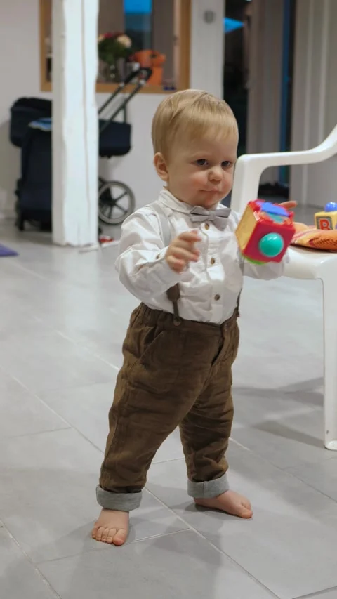 Baby's first steps in suspenders Stock Footage 336332331