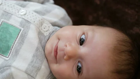 Baby's head close-up. Newborn happy, smiling, his face looks happy. Side view, r Stock Footage 86772902