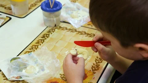 The baby's making figures out of the dough. Close-up Stock Footage 129813304