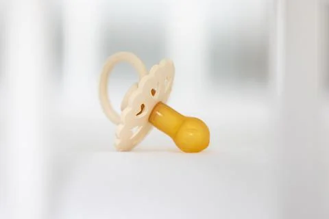 Baby's pacifier on a blurred white background. Stock Photos