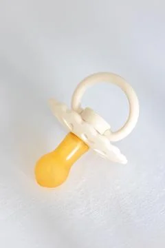 Baby's pacifier on a blurred white background. Stock Photos