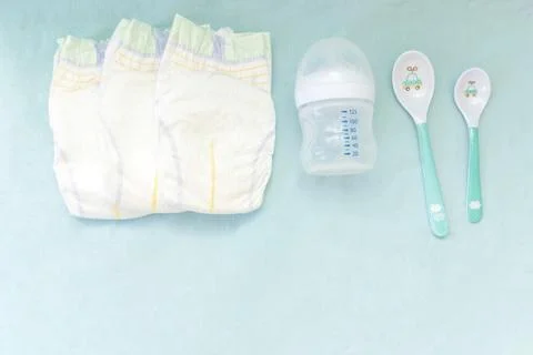 Baby's stuff with copy space. diapers with bottle of milk, hair brush and s.. Stock Photos