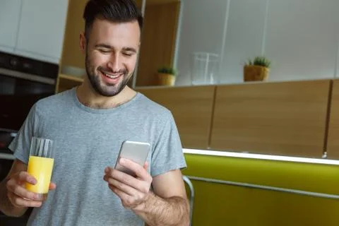 Bachelor man daily routine in a kitchen single lifestyle concept drinking juice Stock Photos