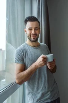 Bachelor man daily routine standing near the window single lifestyle concept Stock Photos