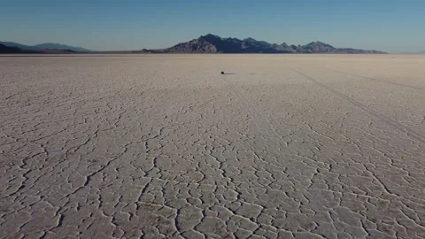Back aerial view of chasing truck driving on Bonneville salt flats at golde.. Stock Footage 276422405