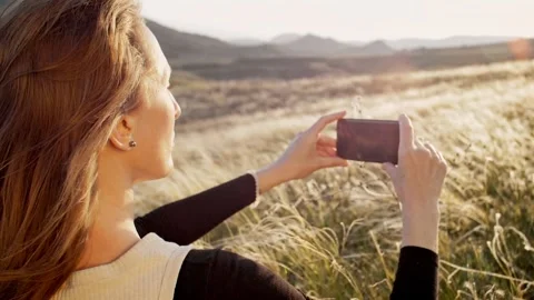 Back and side view slow motion of a woman shooting with a smartphone a mountain Stock Footage 241650332