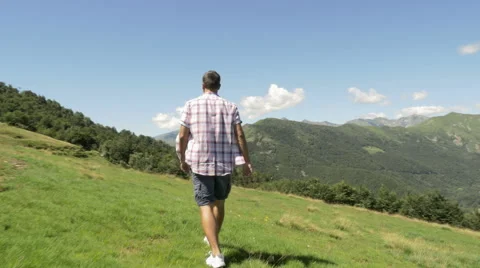 Back and side view of young man hiking in mountain outdoor nature scenery 動画素材 64544341