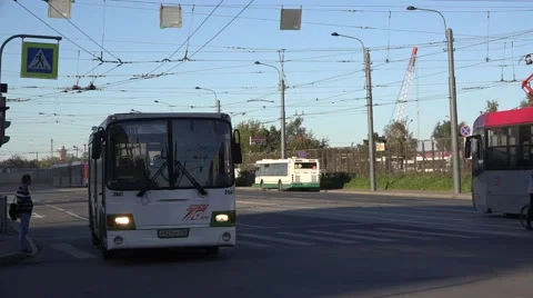 Back-to-back coupled 2-car tram heads to terminus and diesel bus leaves that Stock Footage 67576869