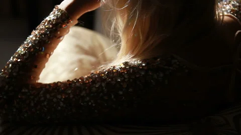 Back of a blonde in a sparkling multi-colored rhinestones evening dress Stock Footage 85873756