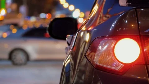 Back of car parked in background of city car traffic, car taillights are on Stock-Footage 123857009