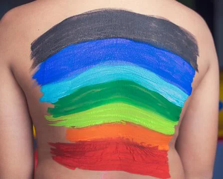 Back of a child painted with rainbow. Stock Photos