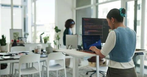 Back, coding and computer screen with business woman at standing desk in Stock Footage 321112491