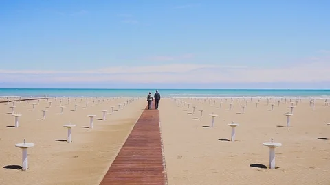 Back couple walking on the beach. A man and a woman going to the sea 動画素材 109285136