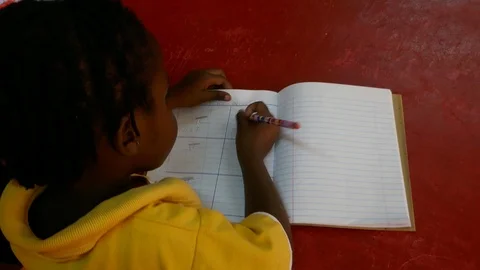 Back of the cutest young black African kid wearing yellow is doing homework. Stock Footage 91935244