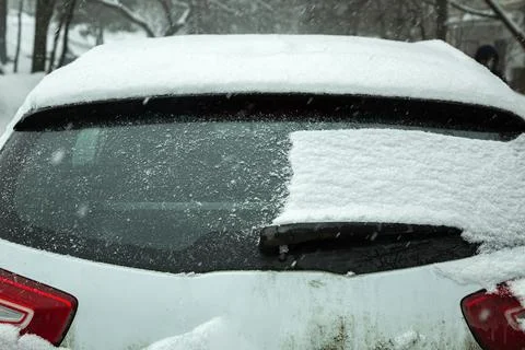 The back door of a crossover half of the window covered with a layer of snow. Stock Photos