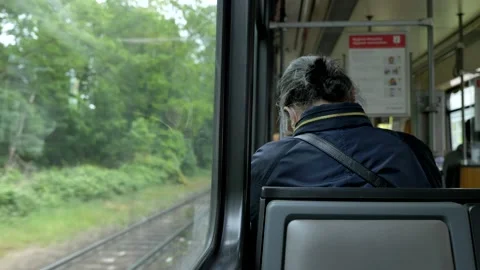 Back of elder female passenger sit in light rail tram. Stock Footage 154499037