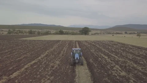Back flight shot on a Farmer in tractor preparing land with seedbed cultivator Stock Footage 116048685