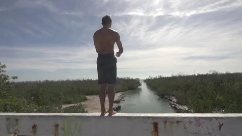 Back Flip off of Bridge into River  Stock Footage 85140267