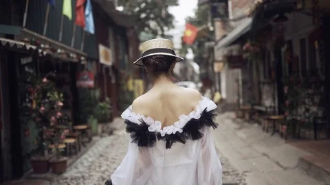 Back follow view to the beautiful and young fashion girl walking along the asian Stock Footage 114796201
