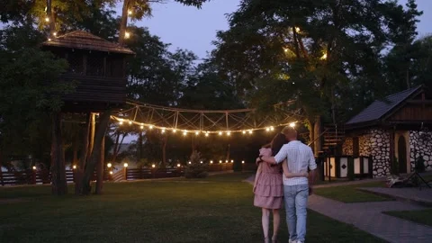 Back frame with two young romantics walking embracing. Happy couple walking on Stock Footage 140878191