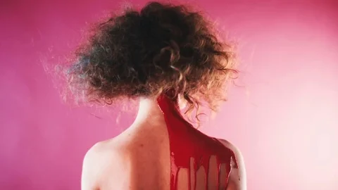On the back of a girl flows a red paint Stock Footage 81701904