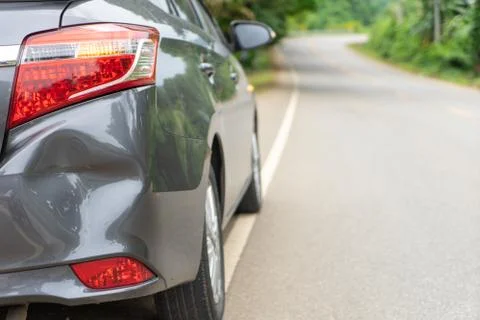 Back of gray car get damaged from accident on the road. Vehicle bumper dent b Stock Photos