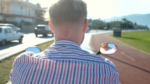 From the back the head of a man on a motorcycle in the summer city Video stock 268684622