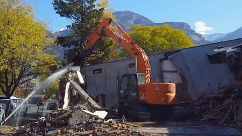 Back hoe pulls down large wall sections during Provo building demolition Stock Footage 97242746