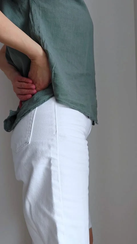 Back hurts. Back ache. Young woman suffering from back pain. Stock Footage 303494185