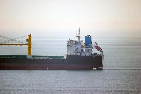 Back of a large ship with yellow cranes at sea on a white background 스톡 사진