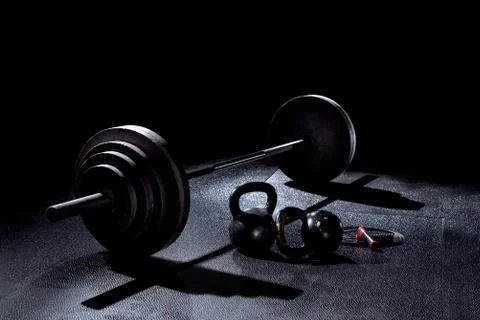BACK LIT image of 365 pound weight  and jump rope on gym floor Stock Photos
