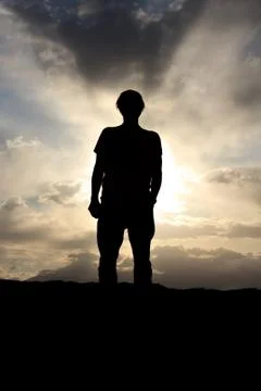 Back lit man before dramatic cloudy sky Stock Photos