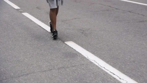 Back look of a young man in hood running on the road near the forest 4K 库存影片 75545147
