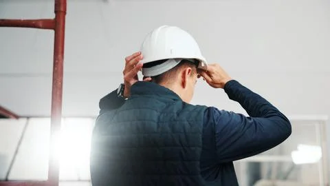 Back, man and engineer at site with helmet, protection and inspection compliance Stock Photos