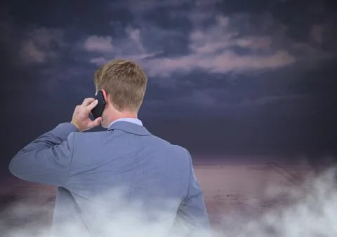 Back of Man Looking at clouds on phone 库存照片