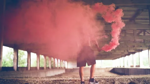 Back of man with red smoke granade movie scene old industrial building Vídeo Stock 230453335
