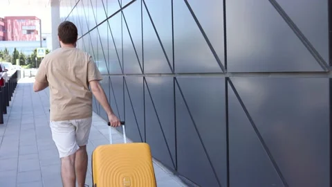 Back man runs a suitcase to the airport or to the hotel, afraid to be late Stock Footage 236557531