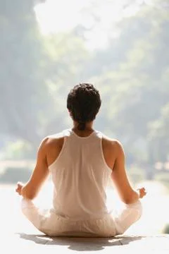 Back of man sitting in yoga posture Stock Photos
