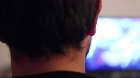 Back of man watching tv on a sofa Stock Footage 12765522