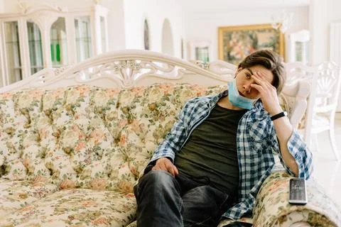 Back of man watching tv on a sofa on quarantine Stock Photos