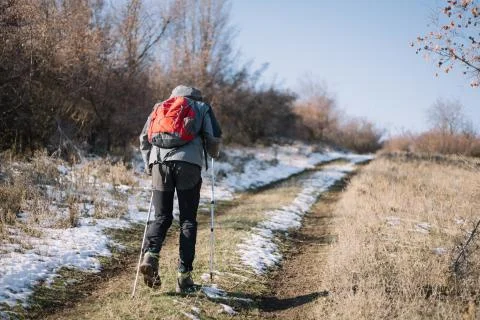 Back of man wearing backpack climbing mountain Foto stock
