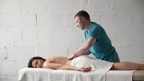 Back massage closeup. Male masseur doing massage scoliosis young dark girl Stock Footage 124943053